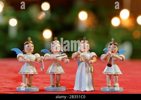 Concerto di Natale con Quattro Angeli: Quattro angeli decorazione che fanno musica di fronte a luci Christmassy Bokeh Foto Stock