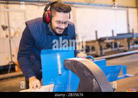 Felice operaio di fabbrica con Monkey Wrench in officina Foto Stock