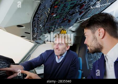 lavoratori aeroportuali maschi che controllano l'aereo Foto Stock