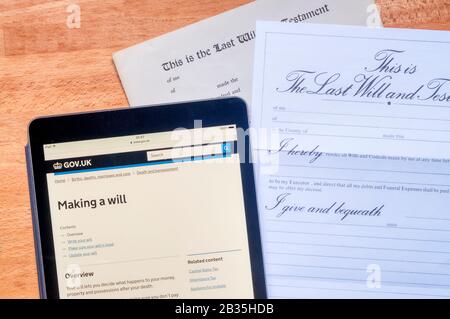 Consigli governativi sulla creazione di un verrà visualizzato su un computer tablet ipad insieme a un paio di moduli prestampati. Foto Stock