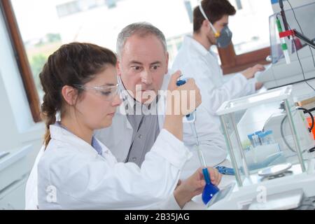 giovane studentessa con professore maschile in laboratorio Foto Stock