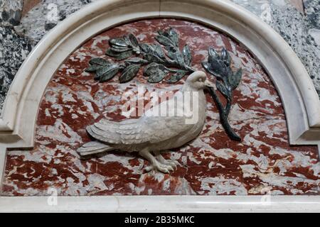 Colomba di pace, la colomba bianca che regge il rilievo del ramo d'ulivo da un muro della basilica di San Pietro nella città del Vaticano Foto Stock