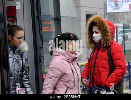 Una donna che indossa una maschera protettiva come precauzione per lo scoppio di Coronavirus entra in un tram.Vice Ministro della Salute dell'Ucraina e il capo medico sanitario del paese, Viktor Lyashko ha riferito il primo caso confermato di un nuovo coronavirus, Covid-19 in Ucraina. Secondo il Ministero della Salute, il 29 febbraio un uomo è stato ricoverato nella città di Chernivtsi, prima di questo, aveva visitato l'Italia durante un viaggio turistico. Foto Stock