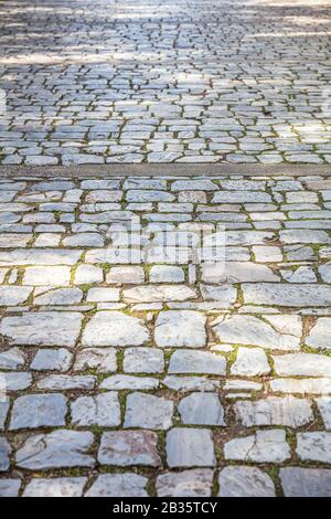 Sentiero pavimentato in marmo di pietra antica, fondo del sentiero lastricato, texture. Vista prospettica ad angolo alto Foto Stock