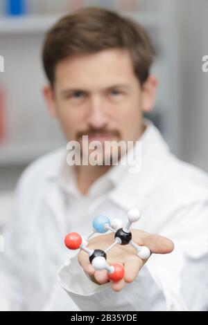 insegnante di laboratorio maschile che mostra un modello di dna 3d Foto Stock
