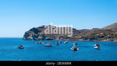 Akrotiri, Grecia - 19 luglio 2019: Barche riunite nella baia del Mar Egeo della spiaggia rossa di Akrotiri Foto Stock