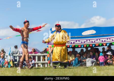 Mongolia, provincia di Khovsgol, Tsagaannuur, festival di Naadam, torneo di wrestling, allenatore, zasuul in mongolo, e wrestler che eseguono danza rituale falco prima della partita Foto Stock