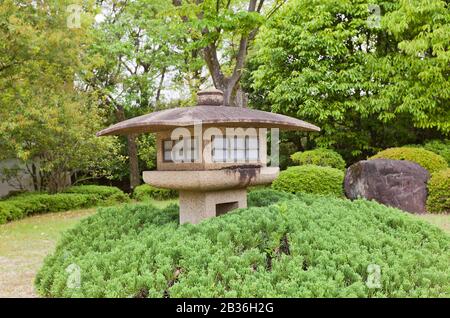 Lanterna di pietra tradizionale (toro) nel Giardino Kokoen vicino al castello di Himeji, Giappone. Il giardino fu istituito nel 1992 per commemorare il 100° anniversario della città di Himeji Foto Stock