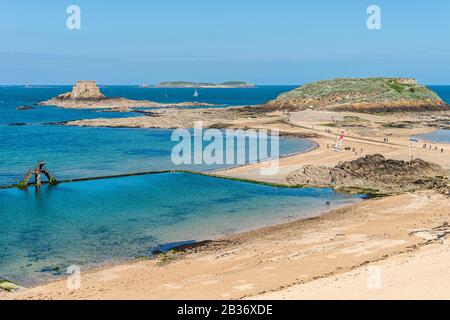 Francia, Ille et Vilaine, Cote d'Emeraude (Costa Smeralda), Saint Malo, Fort progettato da Vauban sull'isola rocciosa Petit-Bé sulla sinistra e Grand-Bé sulla destra, il diving board e la piscina di acqua di mare della spiaggia di Bon Secours in primo piano a bassa marea Foto Stock