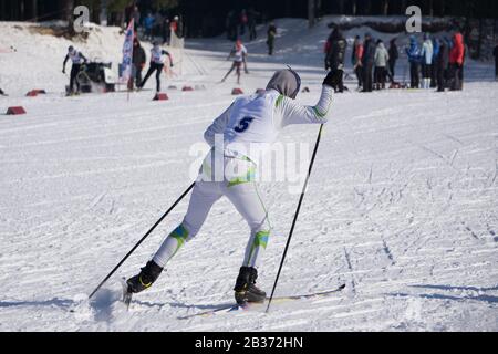 Pista di sci di massa del capretto è fissato sul retro dello sciatore Foto Stock