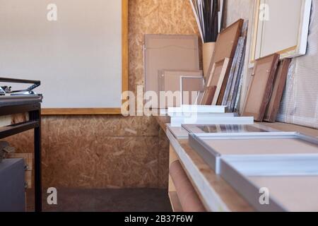 Cornici su un banco da lavoro in studio di incorniciatura dell'immagine Foto Stock