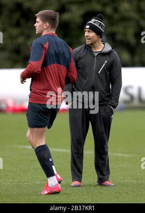 L'Inghilterra Owen Farrell (a sinistra) è guardato da Jonny Wilkinson durante la sessione di formazione a Pennyhill Park, Bagshot. Foto Stock