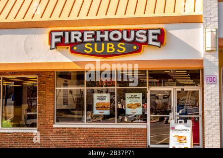 Primo piano orizzontale di media grandezza del negozio di sandwich fast food 'Firehouse Subs' che mostra il marchio e il logo sulla facciata dell'edificio sopra le finestre e l'entrata. Foto Stock