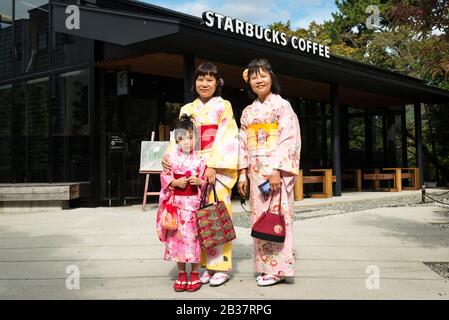 Apparentemente tre generazioni di donne che indossano kimono (che può essere assunto per il giorno) da uno Starbucks vicino ai terreni di Byodo-in, un tempio a Uji Foto Stock