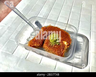 Turkish Street Dessert Burma Kadayif Baklava In Scatola Di Plastica Take Away Concetto Con Polvere Di Pistacchio. Cibo Tradizionale. Foto Stock