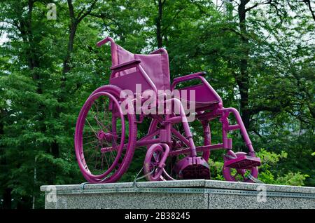 Vecchia sedia a rotelle sul piedistallo di fronte allo stadio nazionale, Sofia, Bulgaria Foto Stock