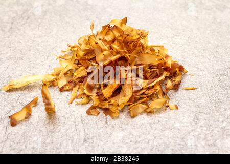 Tonno rasatura katsuobushi, fiocchi di bonito, ingrediente di dashi zuppa giapponese. Su sfondo di pietra, primo piano. Foto Stock