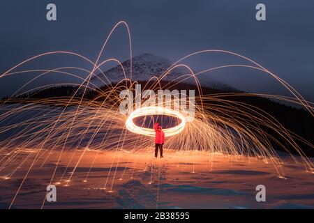 Spettacolo di fuoco con molte scintille nelle montagne invernali notturne. Fotografia di paesaggio Foto Stock