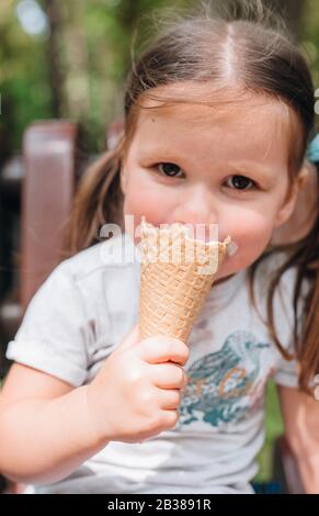 Graziosa bambina di mangiare un gelato all'aperto Foto Stock