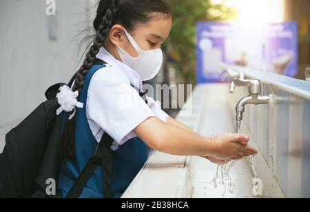 Gli studenti asiatici lavano le mani nel lavabo esterno della scuola. Prevenire Le Malattie Contagiose, Peste. Salute dei bambini, protezione del virus Covid Foto Stock