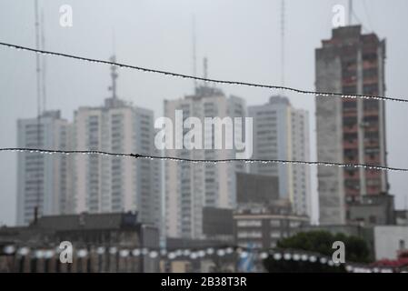 Cavo Clothesline pieno di piccole gocce in una giornata di pioggia con un fuoco selettivo su di loro e profondità di campo molto poco profonda con uno sfondo sfocato Foto Stock