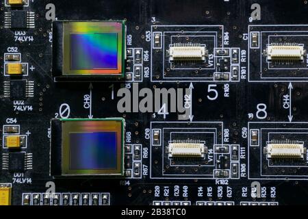 Il processo di controllo di diversi display oled sulla stazione di test. I monitor si spengono e hanno l'arcobaleno sulla superficie. Foto Stock