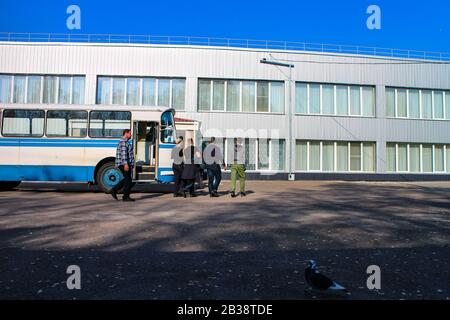 Un gruppo di turismo oscuro esce da un autobus vecchio stile dell'epoca sovietica per entrare nella mensa vicino al reattore di Cernobyl. Foto Stock