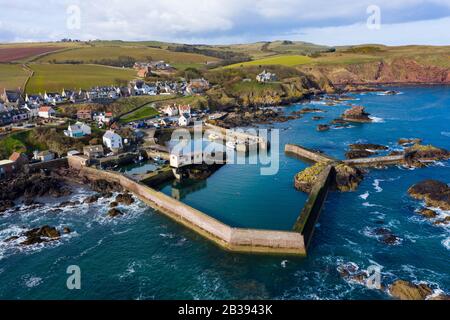 Veduta aerea del piccolo villaggio di pescatori e del porto di St Abbs sulla costa del Mare del Nord nei Confini scozzesi, Scozia, Regno Unito Foto Stock