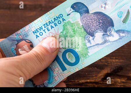 Banconota da 10 dollari neozelandese in mano Foto Stock