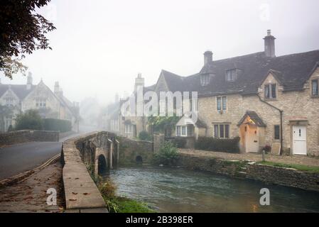 Te by Brook a Castle Combe, Inghilterra, sorge verso High Street. Foto Stock