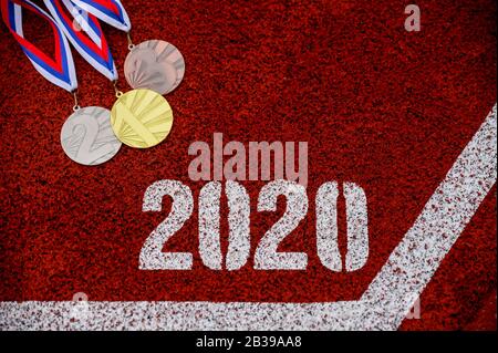 Medaglia set e titolo 2020, sfondo sportivo, pista di atletica rossa in background, foto della cerimonia della medaglia per l'anno 2020. Foto originale per il gioco estivo 2020 Foto Stock