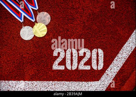 Medal Set e Tittle 2020 su pista sportiva rossa Foto Stock