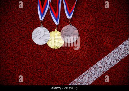 Medaglie d'albero sulla pista atletica, sfondo sportivo, spazio edito rosso, carta da parati Victory. Foto originale per il gioco estivo 2020 a Tokyo Foto Stock