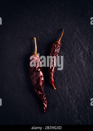 Peperoni rossi caldi. Fondo scuro. Ingrediente piccante Foto Stock