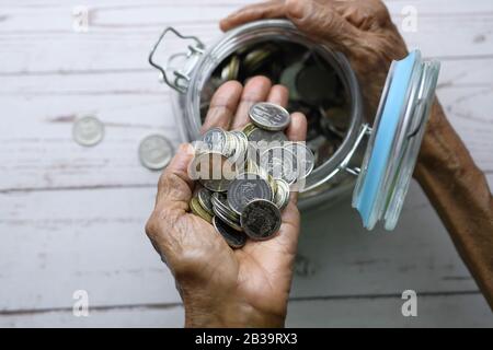 vista dall'alto delle donne anziane che salvano le monete in un vaso Foto Stock
