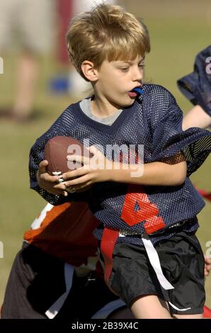 Austin, Texas USA, ottobre 2004: I ragazzi che indossano le protezioni in plastica della bocca corrono in campo durante una partita di calcio della bandiera della lega giovanile per i bambini dai 7 agli 8 anni. ©Bob Daemmrich Foto Stock