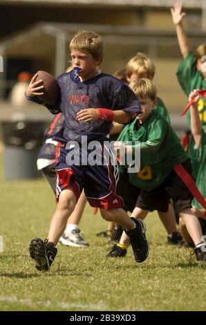 Austin, Texas USA, ottobre 2004: I ragazzi che indossano le protezioni in plastica della bocca corrono in campo durante una partita di calcio della bandiera della lega giovanile per i bambini dai 7 agli 8 anni. ©Bob Daemmrich Foto Stock