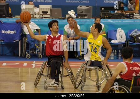 Atene, Grecia 26 SET 04: Azione di pallacanestro per carrozzella da uomo Paralympics tra Brasile (giallo) e Iran (rosso). ©Bob Daemmrich Foto Stock