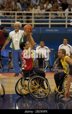 Atene, Grecia 26 SET 04: Azione di pallacanestro per carrozzella da uomo Paralympics tra Brasile (giallo) e Iran (rosso). ©Bob Daemmrich Foto Stock