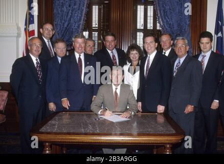 Austin, Texas USA, 29 giugno 1995: I membri della Texas Association of Realtors circondano il governatore del Texas George W. Bush durante una cerimonia di firma del disegno di legge nell'ufficio del governatore al Campidoglio del Texas. ©Bob Daemmrich Foto Stock