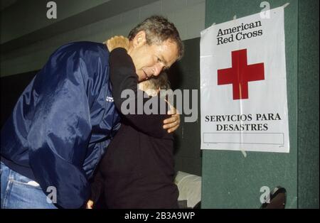 Del Rio, Texas USA, 26 agosto 1998: Il Governatore del Texas George W. Bush confortante una vittima anziana di alluvione ad un rifugio della Croce Rossa. I resti di una tempesta tropicale hanno fatto cadere un piede di pioggia nella zona e causato una devastante inondazione flash in questa città di confine. ©Bob Daemmrich Foto Stock