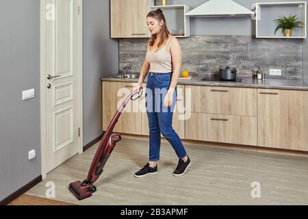 Buon giovane casa pulizia pavimenti parquet con aspirapolvere Foto stock -  Alamy