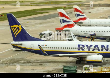 AEROPORTO GATWICK di Londra - APRILE 2019: Boeing 737 Jet gestito da una compagnia aerea di bilancio Ryanair parcheggiata accanto a jet della compagnia aerea rivale British Airways Foto Stock