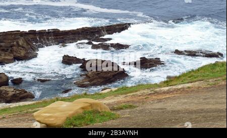 Costa del mare con onde che si infrangono sulle rocce. Monte con bolle e calcare. Foto Stock