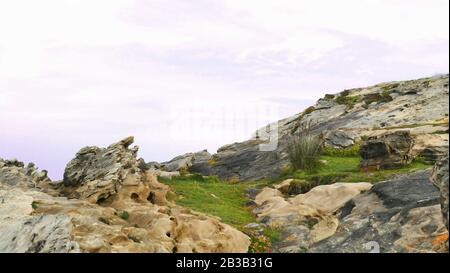 Monte con erba e calcare sulla costa del mare Foto Stock
