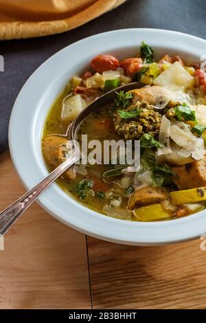 Salsiccia di pollo italiana minestrone zuppa al pistou condita con pesto di basilico e parmigiano grattugiato Foto Stock