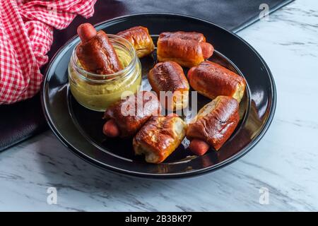 Mini pretzel hot dog maiali in una coperta con senape digione per l'immersione Foto Stock