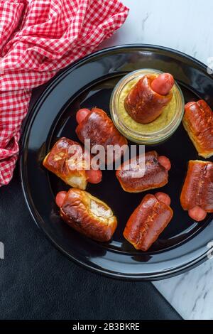 Mini pretzel hot dog maiali in una coperta con senape digione per l'immersione Foto Stock