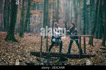 Donne vichinghe in abiti tradizionali con spade in una lotta. Scena cinematografica medievale Foto Stock