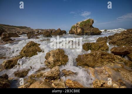 Pietre e onde sulla spiaggia closeup. Crimea Foto Stock